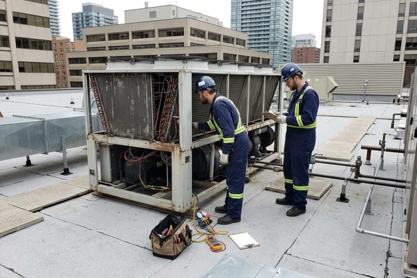 Inspecting an air-cooled chiller on an institutional roof