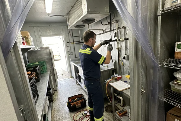 Installing drain line heat tape on a freezer